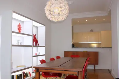 a dining room with a table and a chandelier at Le Maréchal in Nice
