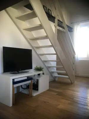 a living room with a tv and a staircase at Charme Méditerranéen Votre pied à terre au Cœur du Port de Nice in Nice