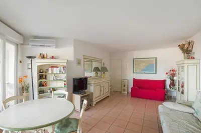 a living room with a red couch and a table at Appartement Lanterne Welkeys in Nice