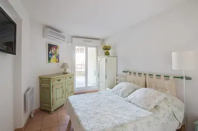 a bedroom with a bed and a dresser and a television at Appartement Lanterne Welkeys in Nice