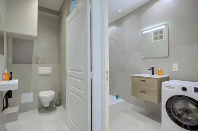 a bathroom with a washer and a toilet and a sink at Maison Bianchi - Raspail in Nice