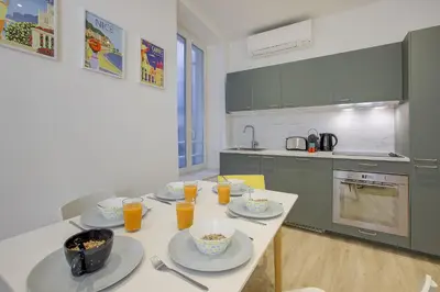 a kitchen with a table with plates of food on it at Maison Bianchi - Raspail in Nice