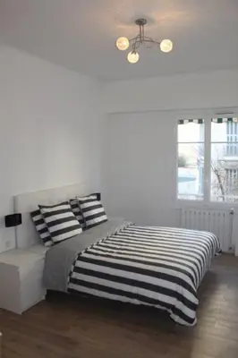 a bedroom with a bed with black and white pillows at Nice Plein Centre, Calme et Proche de la mer in Nice