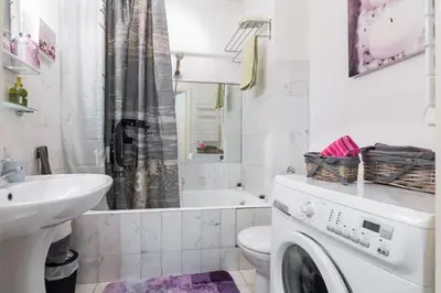 a white bathroom with a washing machine in it at GRAND H -F2, FACE VIEUX- NICE, TERRASSE, ASCENSEUR, CLIMATISATION, Terrace - Nice city center in Nice