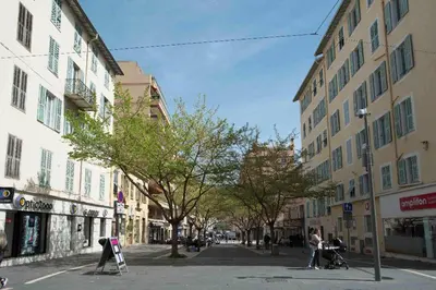 a city street with buildings and people on the sidewalk at Republique Garibaldi in Nice