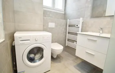 a small bathroom with a washing machine and a toilet at Republique Garibaldi in Nice