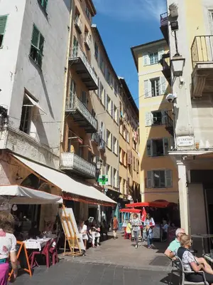 a group of people sitting at tables on a city street at 2 Bedroom Apartment Old Town Centre in Nice