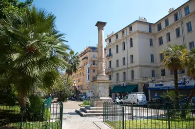 a column in the middle of a street with buildings at AzurAppart Elegant Studio Centre in Nice