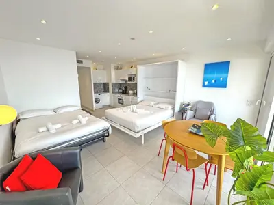 a bedroom with two beds and a table and a dining room at PROMENADE HOLIDAY - ROYAL LUXEMBOURG PROMENADE in Nice