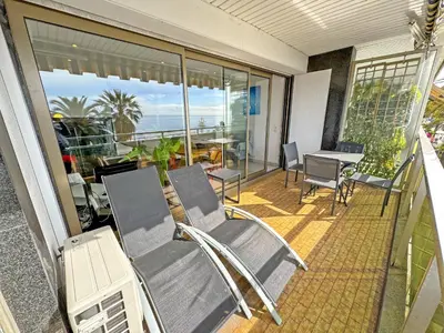 a balcony with two chairs and a table on a patio at PROMENADE HOLIDAY - ROYAL LUXEMBOURG PROMENADE in Nice