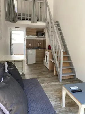 a living room with a couch and a staircase at Nice Sunshine in Nice
