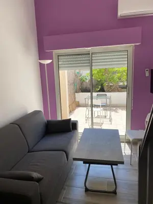 a living room with purple walls and a couch and a table at Nice Sunshine in Nice