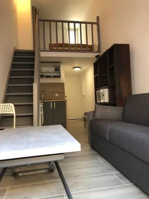 a living room with a couch and a staircase at Nice Sunshine in Nice