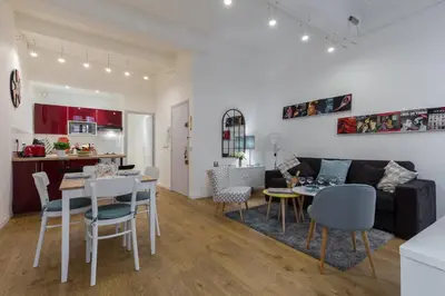 a living room and kitchen with a table and chairs at Large one bedroom flat in the Old Town in Nice