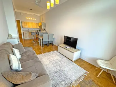 a living room with a couch and a tv at PROMENADE HOLIDAY - ROCAMARE PROMENADE in Nice