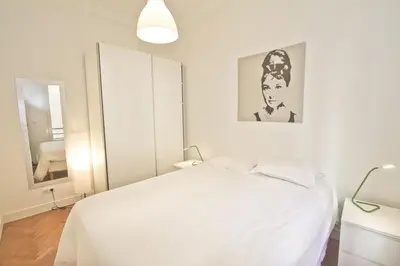 a white bedroom with a bed and a mirror at PROMENADE HOLIDAY - SOLEMAR PROMENADE in Nice