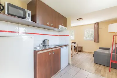 a kitchen and living room with a couch at Appart'City Classic Nice Acropolis in Nice