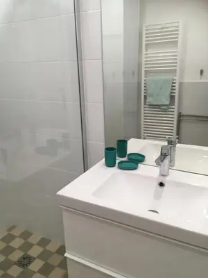 a white bathroom with a sink and a shower at Les Gérardines by EnjoyNice, 3-room with Airco and balcony in Nice