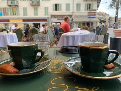two cups of coffee and cookies on a table at Chez Kari-top location in charming old town in Nice