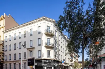 a large white building on a city street at Hotel 66 Nice in Nice
