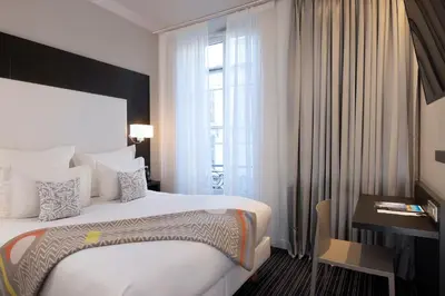 a hotel room with a large bed and a window at Hotel 66 Nice in Nice