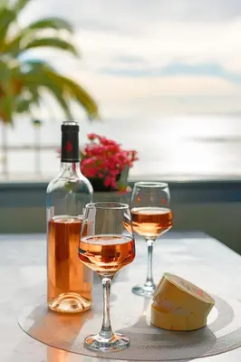 two glasses of wine and a bottle on a table at Sea view luxury apartment in Saint-Laurent-du-Var