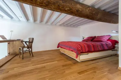 a bedroom with a bed and a wooden floor at Le Noble in Scenic Villefranche Sur Mer in Villefranche-sur-Mer