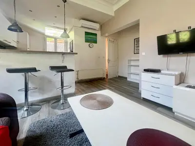 a living room with two bar stools and a tv at Proche promenade des anglais et de la mer in Nice