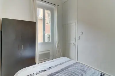 a white bedroom with a bed and a window at Lovely Cosy Flat in Nice old town in Nice
