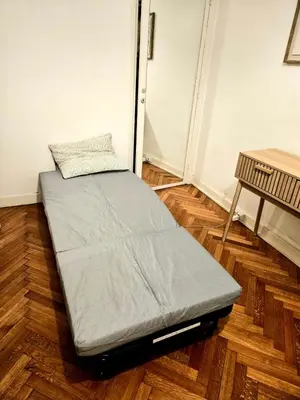 a bed sitting on a wooden floor in a room at Seaflat in Nice in Nice