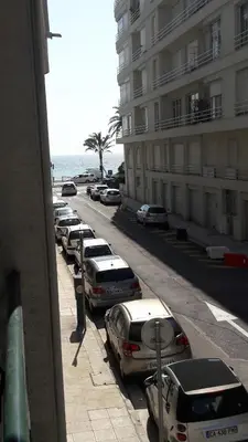 a row of cars parked on a street next to a building at Seaflat in Nice in Nice