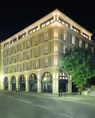 a large white building with a tree in front of it at La Résidence de La Réserve in Beaulieu-sur-Mer