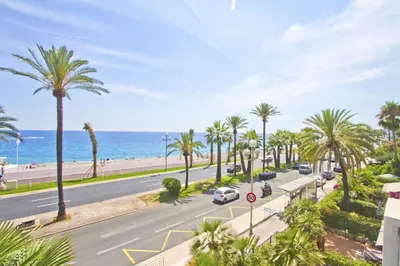 a city street with palm trees and the ocean at PROMENADE HOLIDAY - ORIENT & SEA in Nice