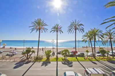 a view of a parking lot with palm trees and the beach at PROMENADE HOLIDAY - COSY SEA FRONT STUDIO in Nice