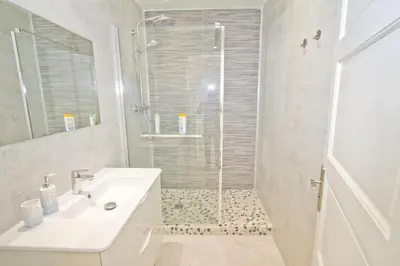a white bathroom with a shower and a sink at PROMENADE HOLIDAY - AZUR PROMENADE in Nice