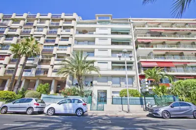a large apartment building with cars parked in front of it at PROMENADE HOLIDAY - AZUR PROMENADE in Nice