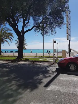 a red car parked on a street near the beach at Studette en plein cœur du Vieux Nice in Nice
