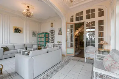 a living room with white furniture and a chandelier at Villa COLLIN - Promenade des Anglais in Nice