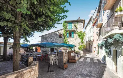 a street with tables and umbrellas in a city at Awesome Home In La Gaude With Kitchen in La Gaude