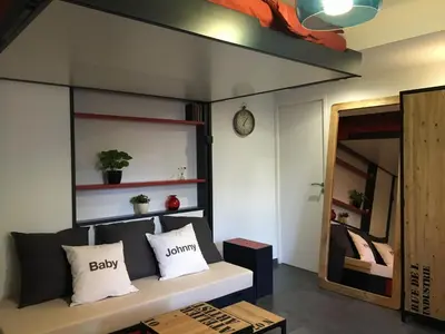 a living room with a couch and a mirror at Studio 33 in Nice