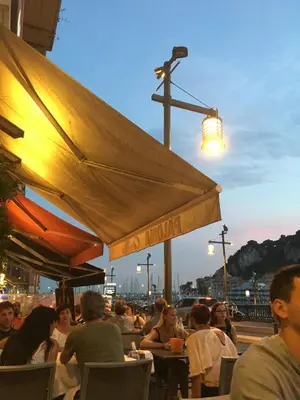 a group of people sitting at an outdoor restaurant at Studio 33 in Nice