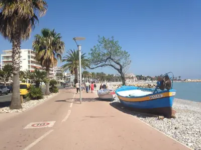 a boat sitting on a beach next to a street light at Le Cros de Cagnes in Cagnes-sur-Mer