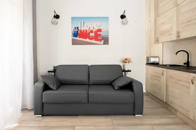 a living room with a couch and a kitchen at Nice Centre Flat - Modern, Quiet and Brand New in Nice