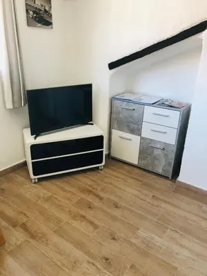a living room with a flat screen tv and a wooden floor at F2 Centre - Gare in Nice