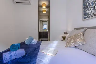 a bedroom with a white bed with two books on it at MY CASA - PARADIS - Carré d Or 1 room - Balcony Sea View in Nice