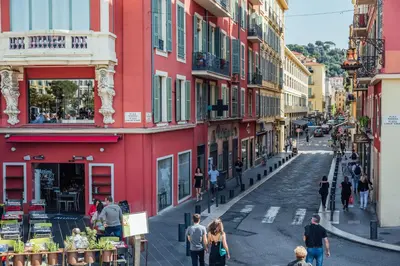 a group of people walking down a street with buildings at 