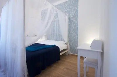a small bedroom with a canopy bed and a desk at 