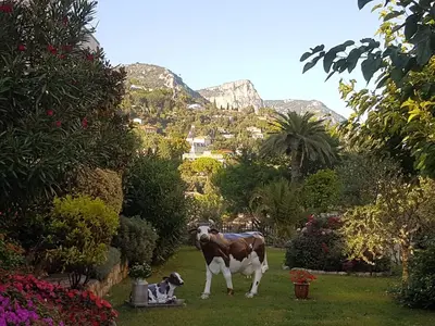a statue of a cow and a dog in a garden at Mikado in La Gaude