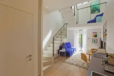 a living room with a staircase and a blue chair at Residence Tonduti in Nice