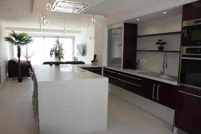 a kitchen with a large white island in a room at Appartement 3 pièces Nice Promenade des anglais dernier étage vue mer solarium in Nice
